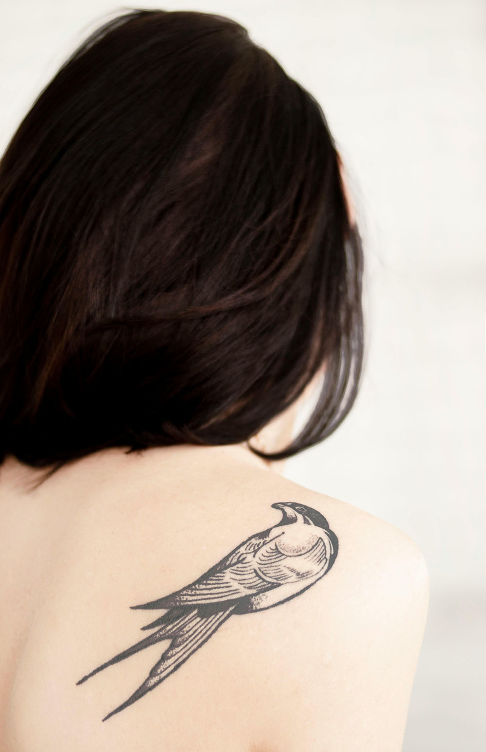 Bird tattoo on a womans shoulder.